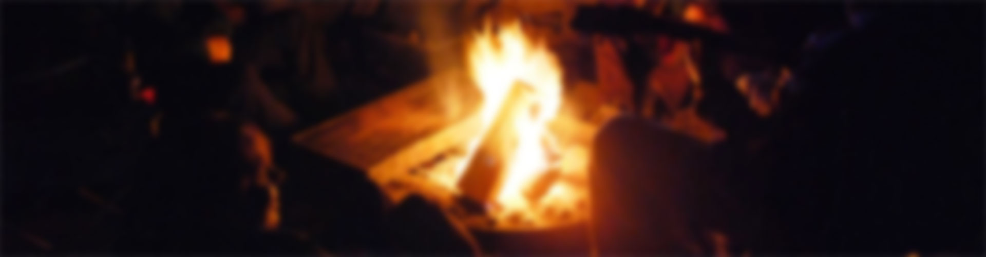A group of people sitting around a fire for a beer poke